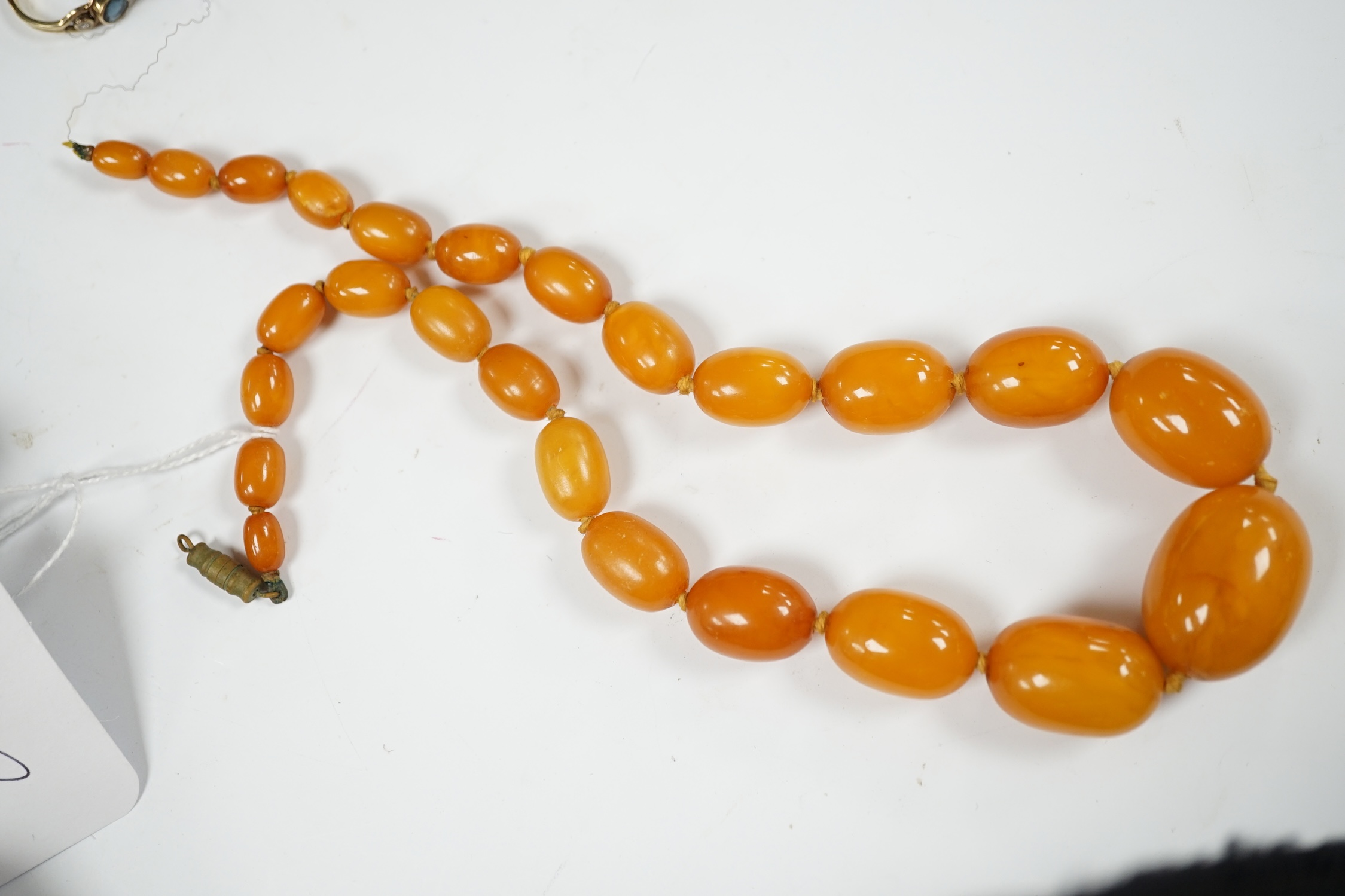 A single strand graduated oval amber bead necklace, 44cm, string broken, gross weight 39 grams. Condition - poor